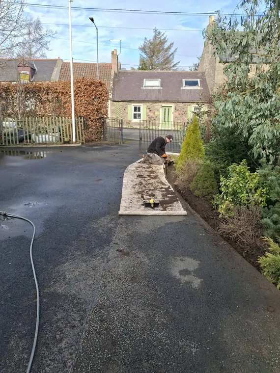 Setting kerbs to line and level along a driveway before the surface goes down.