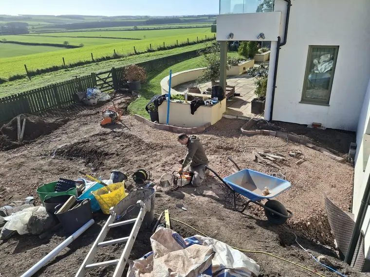Two on the tools and a full site set-up — big garden builds get run like a build, not a weekend job.