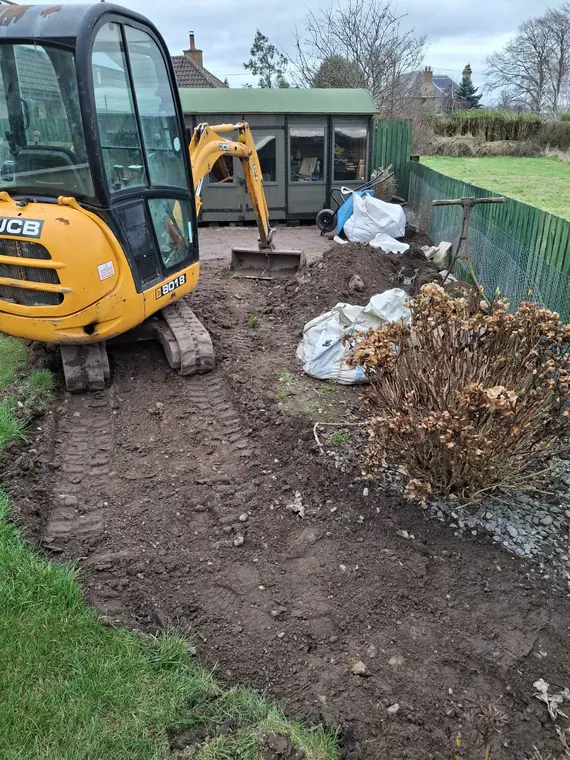 Mini digger in and topsoil stripped — levels get set properly at this stage or nothing above them sits right.