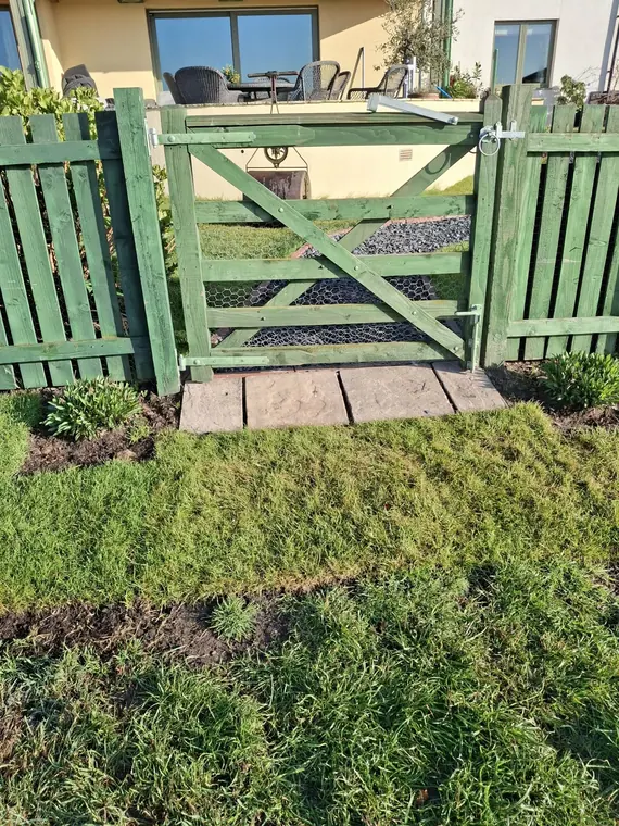 A stone slab threshold set into the turf at the gate, so the entrance stays dry underfoot.
