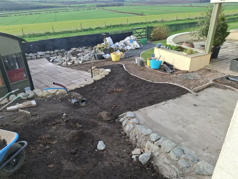 Mid-project: beds shaped, boulders set and the paved area taking form against the view.