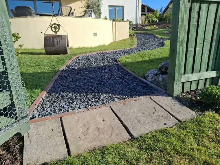 Reclaimed stone slabs bedded into a gravel run to take the wear at a gateway.