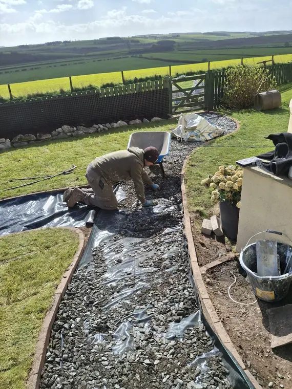 Membrane down and gravel spread by hand around the curve — no wheelbarrow ruts left behind.