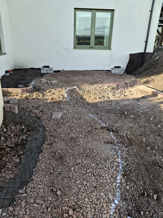 Excavating to depth on the path run, with the sweep of the curve set out in white line.