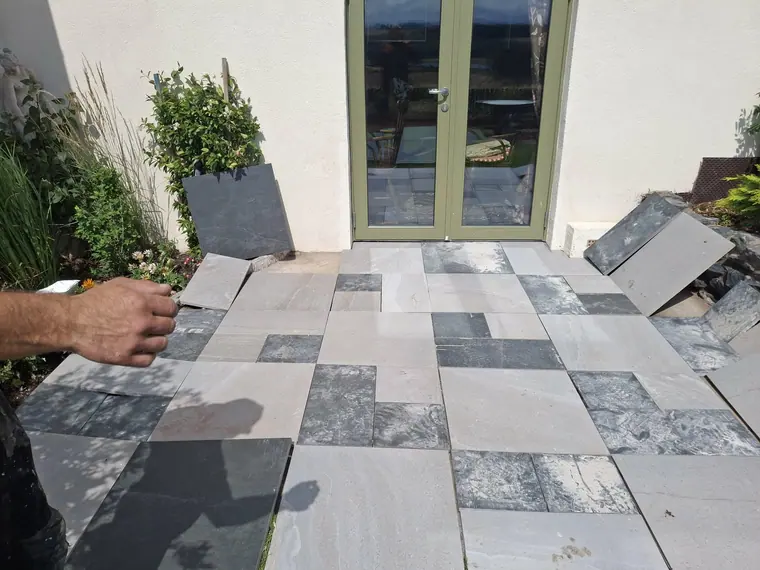 Setting out contrasting porcelain slabs dry first — the pattern gets agreed before anything is bedded.