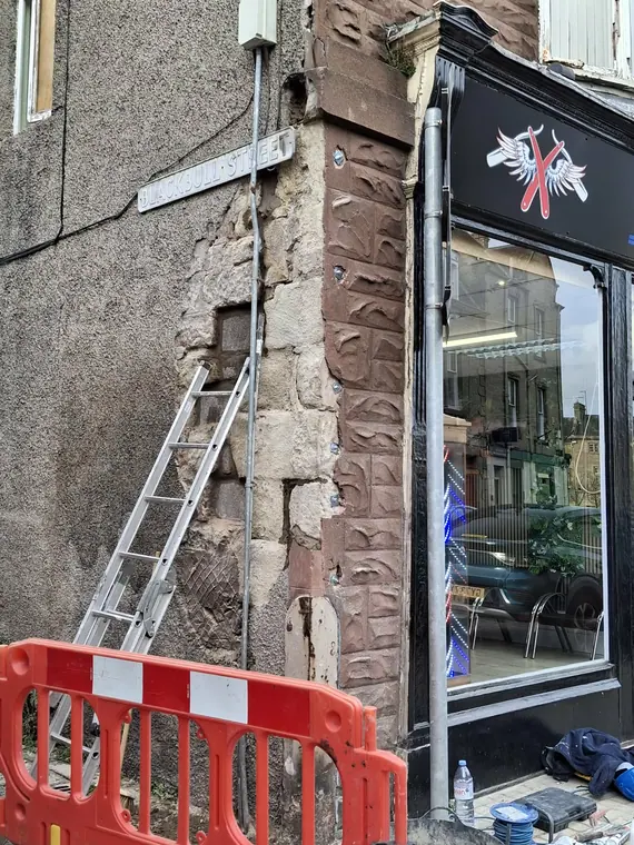 New sandstone indents going into a commercial corner, matched to the original tooling and bed height.