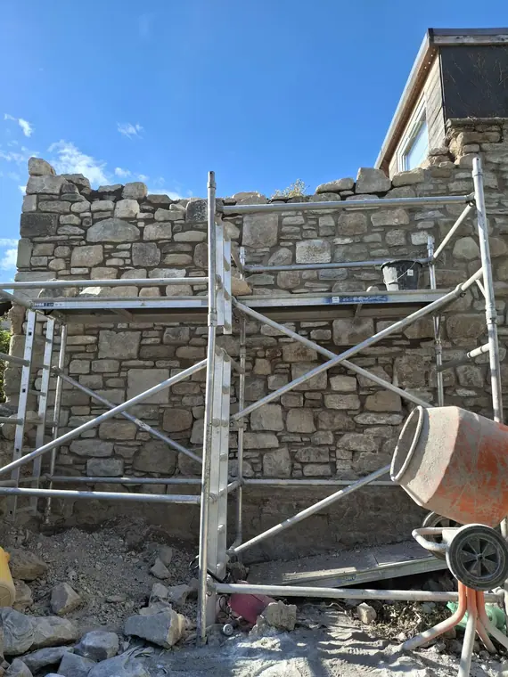 Mixing on site so each batch of mortar matches the last — colour consistency is what makes old walls look untouched.