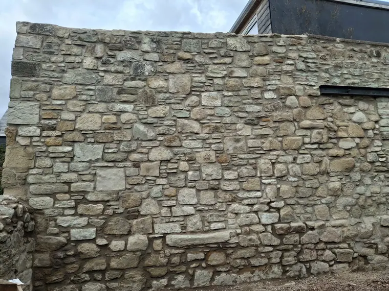 The same wall finished: every joint packed and brushed back so the stone, not the mortar, reads first.