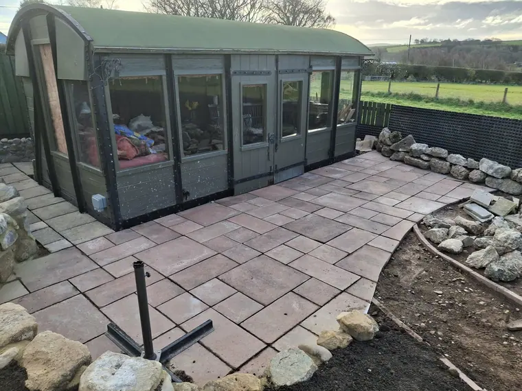 The same sun room after landscaping, with level paving laid across the full frontage