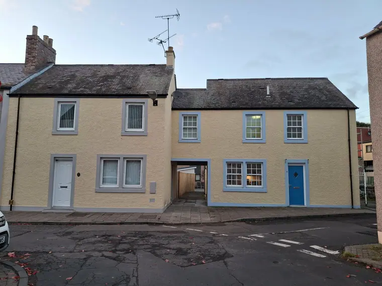 A full house exterior in soft cream with pale blue joinery — repainted top to bottom off ladders.